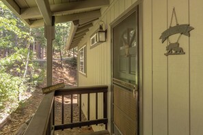 A porch with a 'Welcome' sign, a 'Mama Bear on Duty' sign, and a metal railing. - Canopy Pines- Access to pool/lake (Arnold)