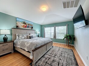 A bedroom with a bed, bedside tables, a painting, a window with blinds, and a plant. - PROMO Magical 6 BR Villa, Pool/Spa, Windsor Hills - by Blue Sky Villas (Kissimmee)