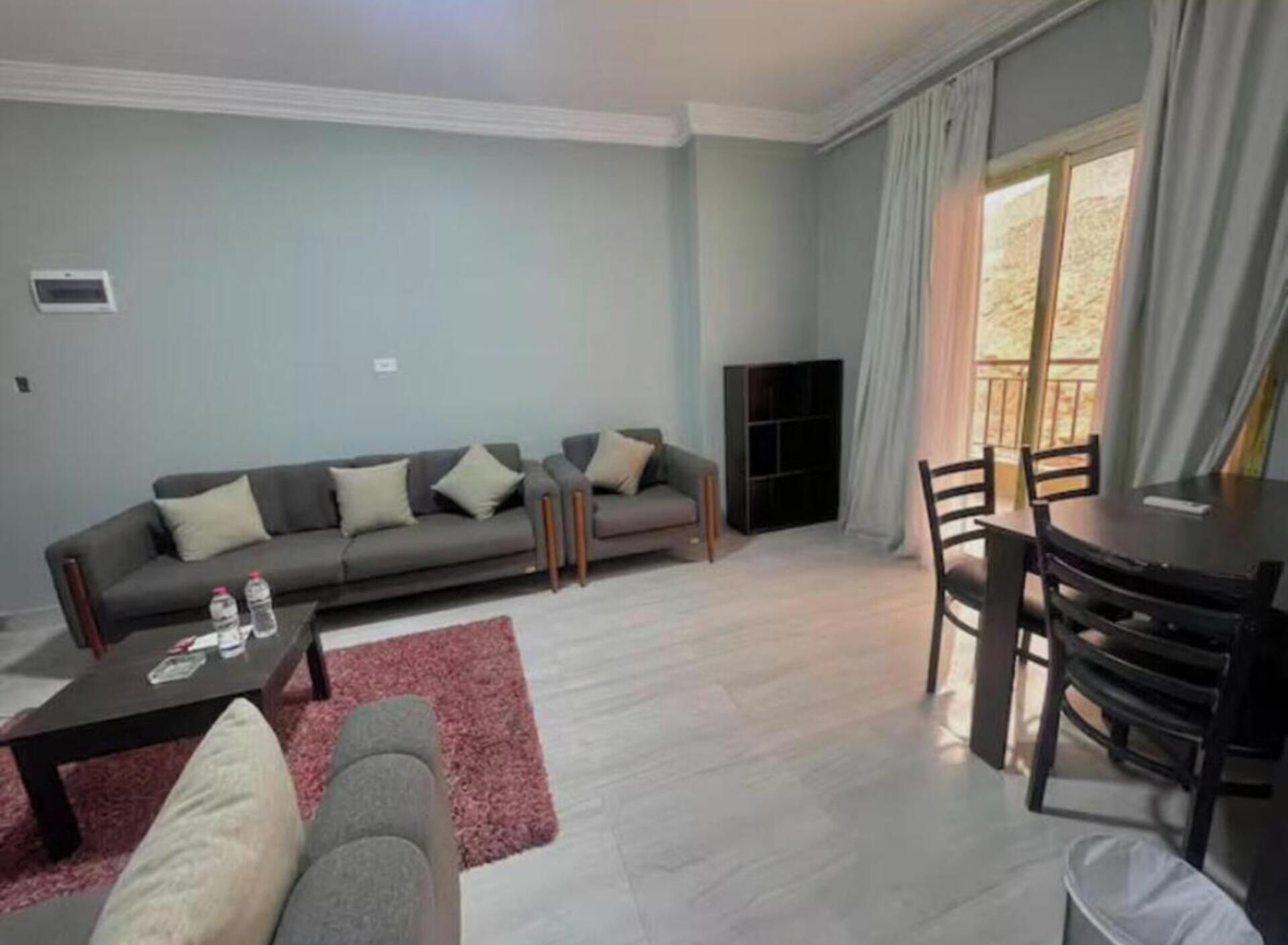 Een woonkamer met een bank, salontafel en een eethoek.