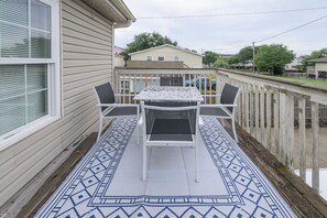 A balcony with a table and chairs, a patterned rug, and a view of a house and trees. - 3 BR, Walk to the Beach Townhouse in Surfside Beach! Sandy Sea (Surfside Beach)