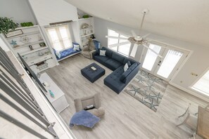 A spacious living area with a high ceiling, a ceiling fan, and a large window. - 3 BR, Walk to the Beach Townhouse in Surfside Beach! Sandy Sea (Surfside Beach)