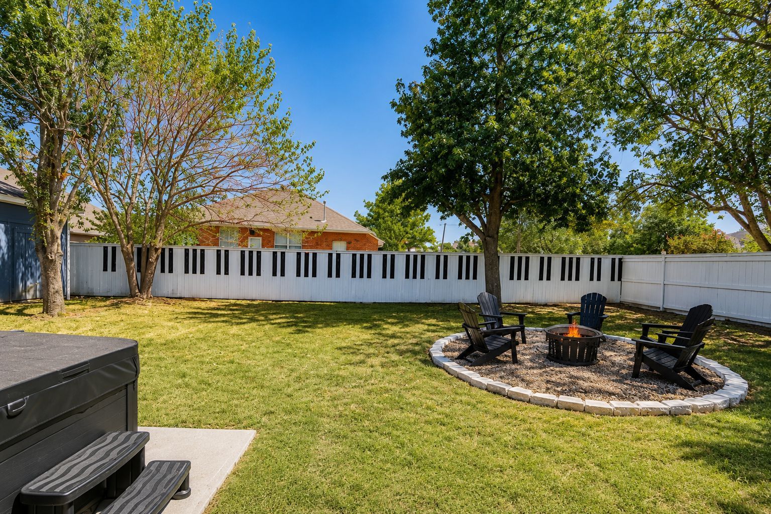 A backyard with a fire pit, outdoor seating, a barbecue grill, and a shed.