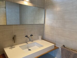 Ein Badezimmer mit Waschbecken, Spiegel und Handtuchhalter.