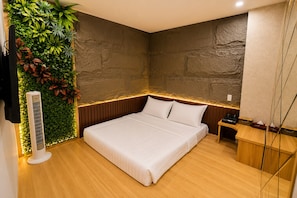 Ein modernes Schlafzimmer mit Bett, Holz-Kopfteil und einer Wand-Klimaanlage.