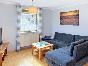 En moderne stue med sofa, sofabord og et billede på væggen.
