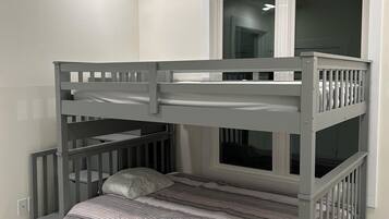 A bunk bed with a window above, a white ceiling, and a marble-patterned floor.