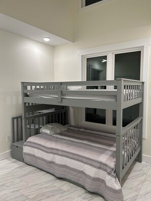 A bunk bed with a window above, a white ceiling, and a marble-patterned floor.