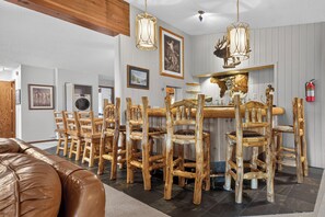 A dining area with wooden chairs and a bar counter. - Silverado II Unit 631 Exquisite 4 bedroom penthouse, private deck, clubhouse (Winter Park)
