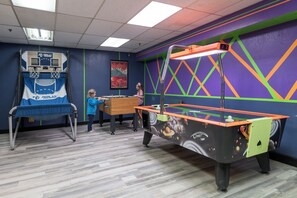 Une salle de loisirs équipée d’un baby-foot, d’un panier de basket et d’une table de billard.
