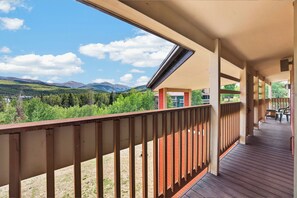 Eine Holzterrasse mit Blick auf Berge und einen klaren Himmel.