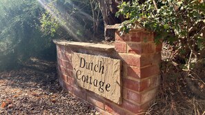 A brick wall with a wooden sign that reads 'Dutch Cottage.' - Dutch Cottage Spacious 2-bed w Large Garden (Halstead)