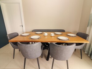 A dining table with six chairs, plates, and a pitcher. - CEOL NA MARA, family friendly, with a garden in Doonbeg, County Clare (Doonbeg)