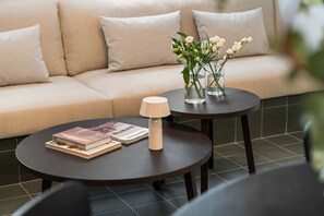 A modern living area with a sofa, two small tables, a lamp, and a magazine. - Malasaña · Reformado · Gran Vía a 3 min a pie (Madrid)