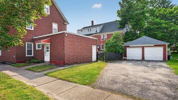 A residential property with a brick house, a detached garage, and a well-maintained lawn.
