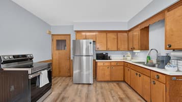A modern kitchen with wooden cabinets, stainless steel appliances, and a tiled backsplash.
