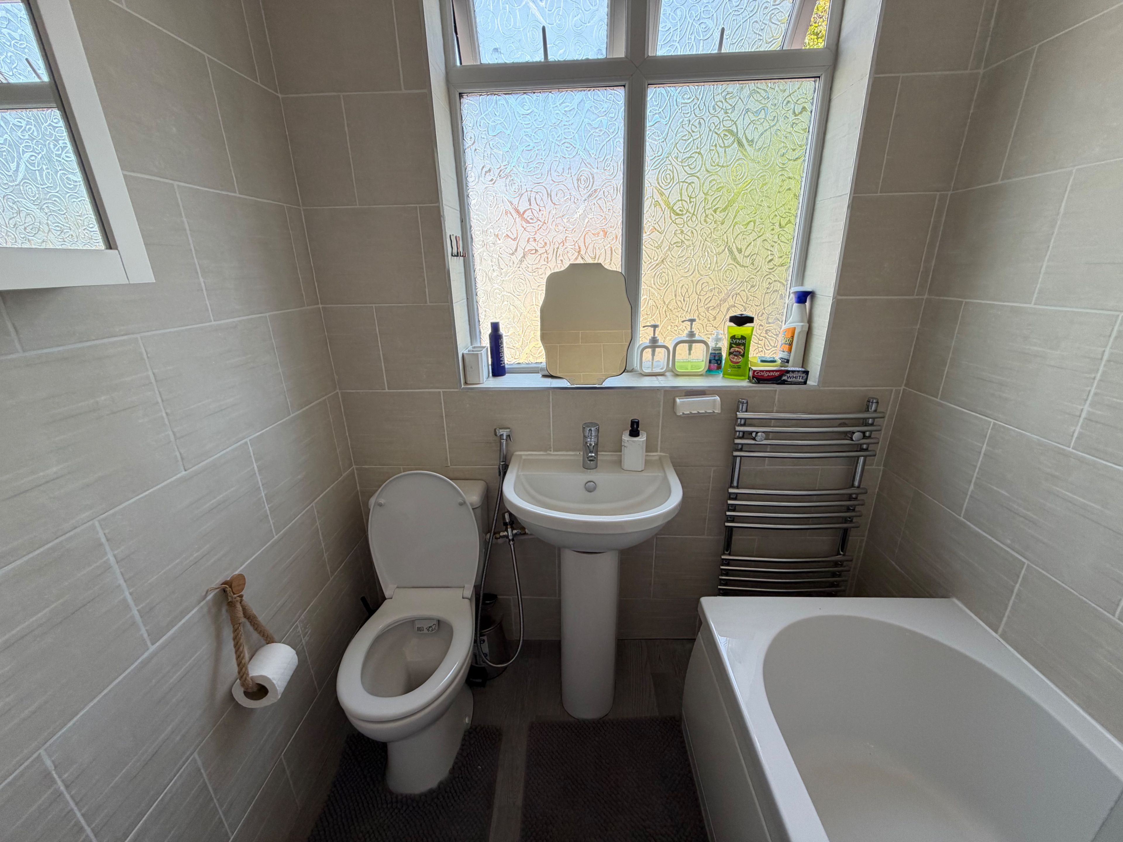 Un baño pequeño con inodoro, lavabo y bañera.