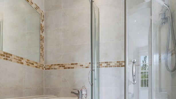 Ein Badezimmer mit Duschkabine, Waschbecken und Toilette.