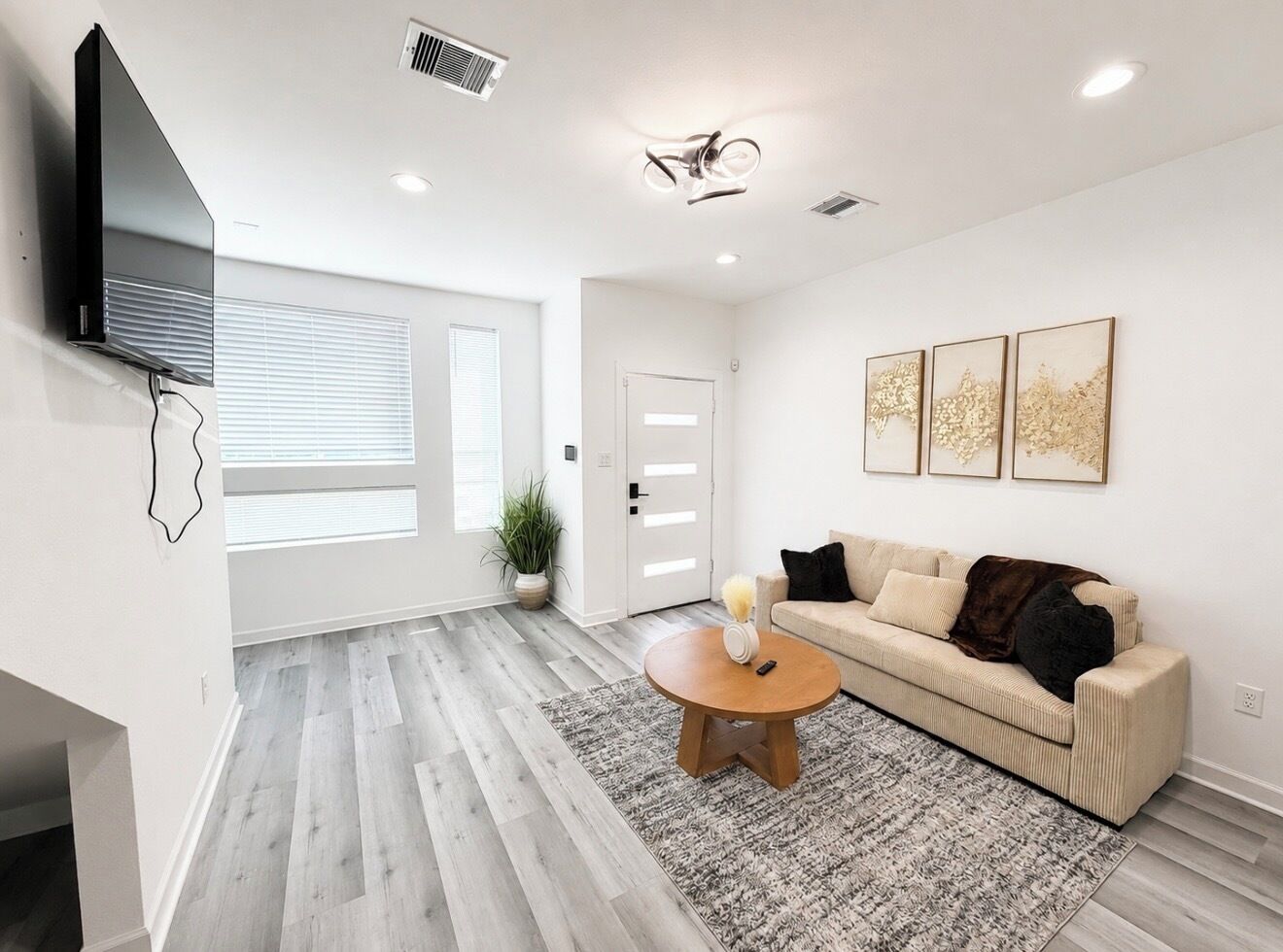 A modern living room with a sofa, coffee table, and artwork on the wall.