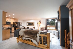 A spacious living area with a large bed, a dining table, and a kitchen area with modern appliances. - Ski Hill Powder Retreat: Downtown Breck, Walk to Gondola (Breckenridge)