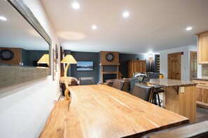 A modern kitchen with a wooden island, bar stools, and a fireplace. - Ski Hill Powder Retreat: Downtown Breck, Walk to Gondola (Breckenridge)