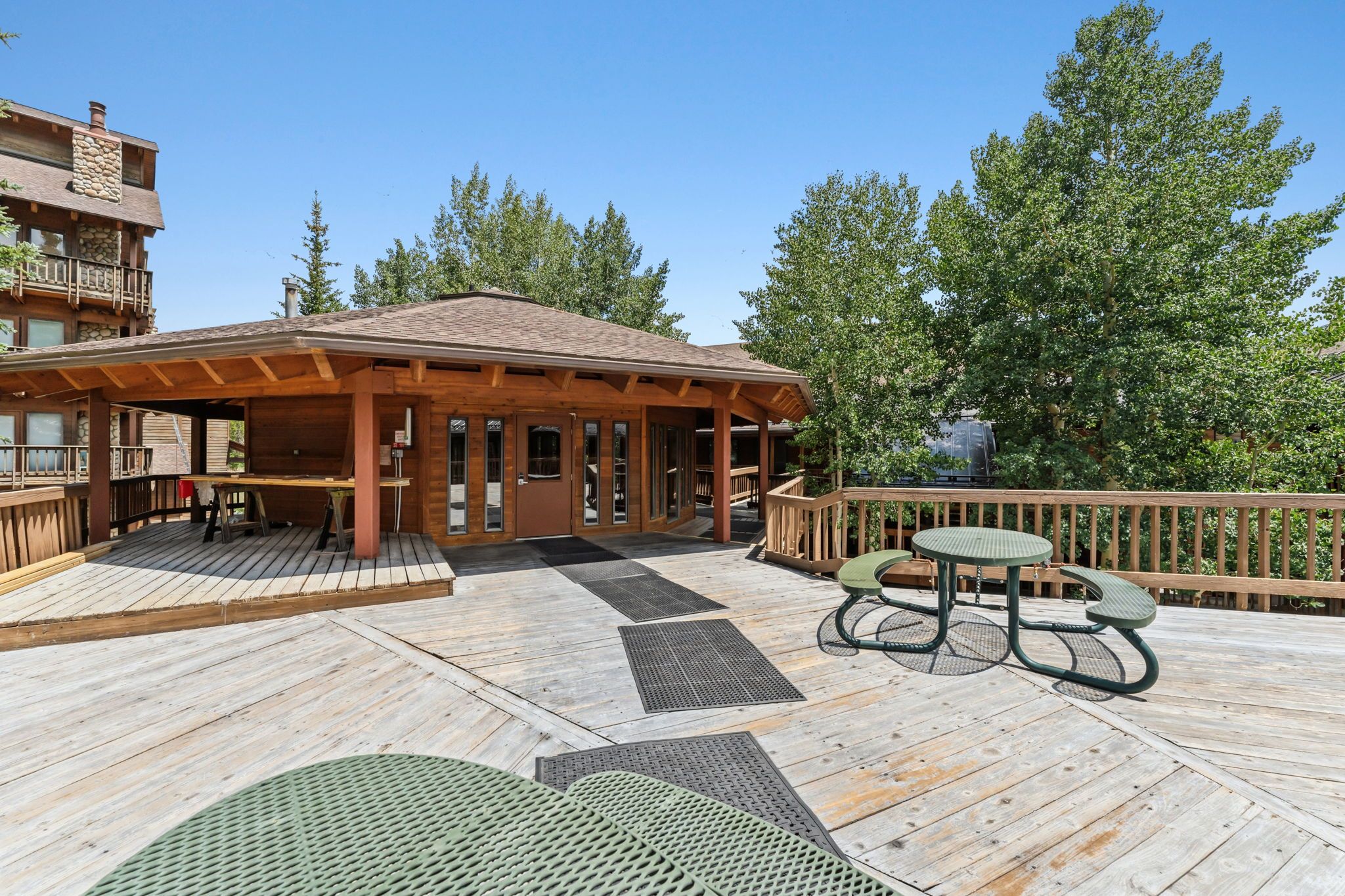 A wooden deck with a covered seating area and a table.