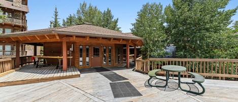 A wooden deck with a covered seating area and a table.