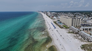 Eine Küstenstadtlandschaft mit Strand, Hotels und blauem Himmel.