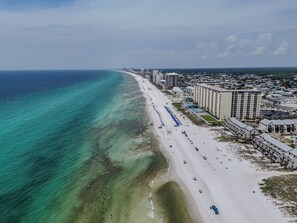 Een kuststadsgezicht met een strand, hotels en een heldere lucht.