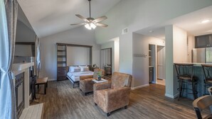 A spacious room with a bed, a seating area with a chair, a dining table, and a kitchenette. - Lake Aspen Getaway by Innsbrook Vacations! (Innsbrook)