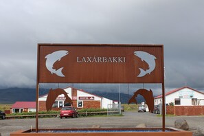 A sign with the name 'Laxårbakki' and two whale silhouettes, indicating a location related to whales. - Relaxing and family-friendly hotel by the ring road yet surrounded by nature (Akranes)