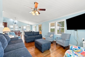 A spacious living room with a ceiling fan, a dining area with a table and chairs, and a kitchen in the background. - Rest Coast Repeat-Just a short walk to the beach! (Atlantic Beach)