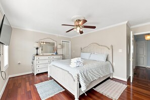 A bedroom with a bed, a dresser, a mirror, a ceiling fan, and a door. - Rest Coast Repeat-Just a short walk to the beach! (Atlantic Beach)