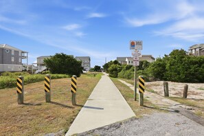 A pathway leading to a residential area with houses, a beach access sign, and a 'No Parking' sign. - Rest Coast Repeat-Just a short walk to the beach! (Atlantic Beach)