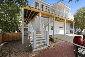 A two-story house with a covered porch, a staircase, and a garage. - Rest Coast Repeat-Just a short walk to the beach! (Atlantic Beach)