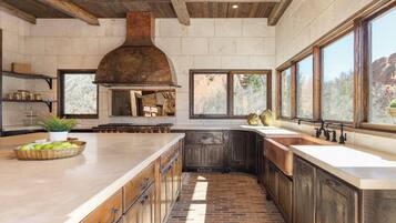 A spacious kitchen with a large island, a built-in oven, and a rustic ceiling.