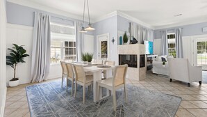 A spacious living room with a dining area, a fireplace, and a sofa. - Paradise Escape | 3BR Beach Home in Crystal Beach (Destin)