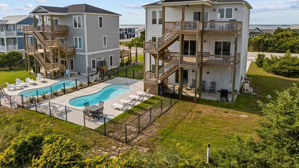 A residential complex with multiple two-story buildings, a swimming pool, and outdoor seating areas. - Waverlie’s Watch | Private Pool + Ocean and Sound Views (Emerald Isle)
