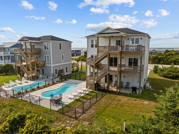 A residential complex with multiple two-story buildings, a swimming pool, and outdoor seating areas. - Waverlie’s Watch | Private Pool + Ocean and Sound Views (Emerald Isle)
