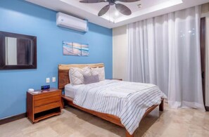 Una camera da letto con un letto, un comodino e una ventola a soffitto.