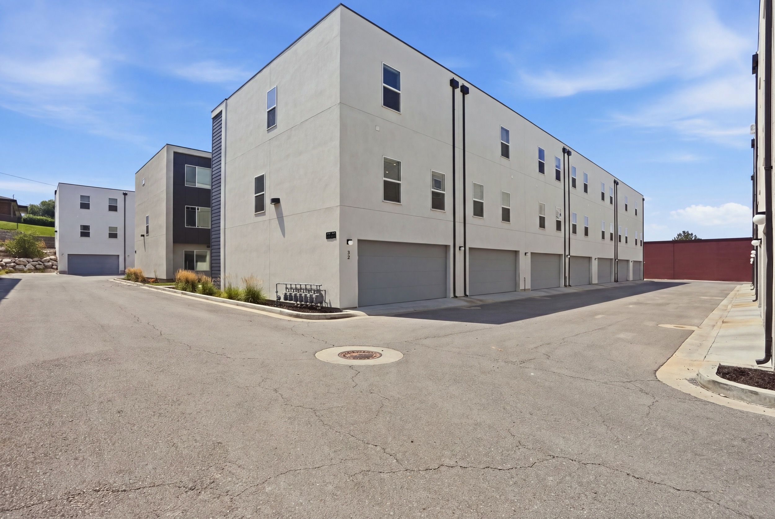 A multi-story building with a flat facade, multiple garage doors, and a clear sky.