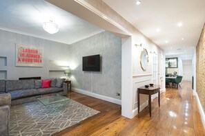 A modern living room with a grey sofa, a glass coffee table, and a patterned rug. - Luxurious & Spacious 2 Bed Basement Flat in South Kensington - Pass the Keys (London)