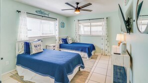 A room with two beds, a ceiling fan, and a window with curtains. - A-Wave for Everyone - Full duplex + 2 Pools! (New Smyrna Beach)