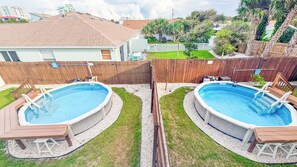 A residential backyard with two above-ground swimming pools, a wooden deck, and a fenced area. - A-Wave for Everyone - Full duplex + 2 Pools! (New Smyrna Beach)