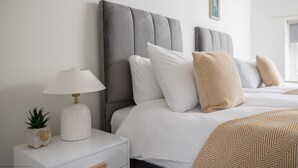 Ein Hotelzimmer mit Bett, Nachttisch, Lampe und einer Zimmerpflanze.