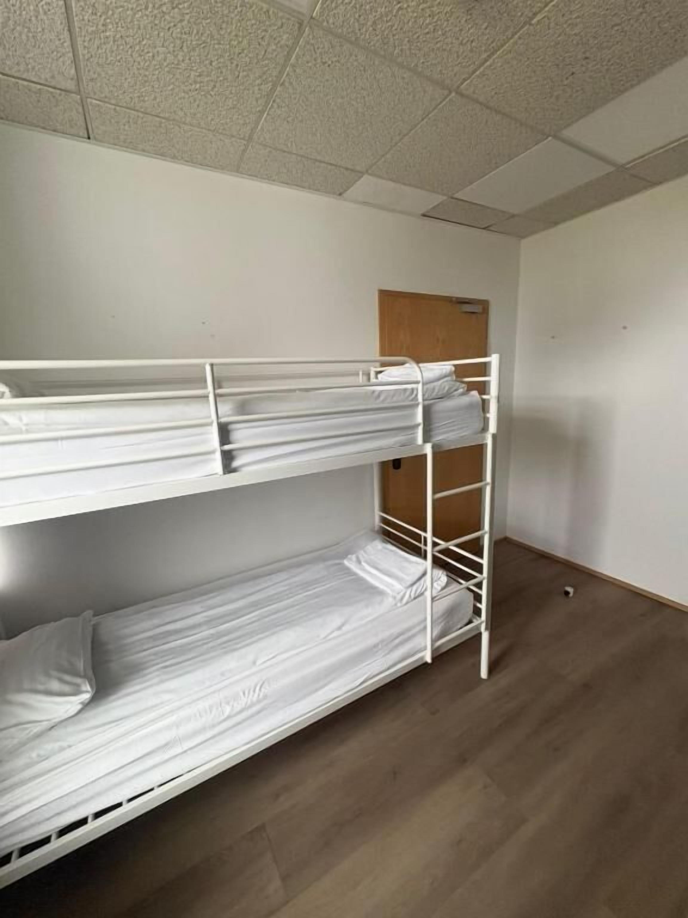 A bunk bed in a room with a wooden floor and a white ceiling.