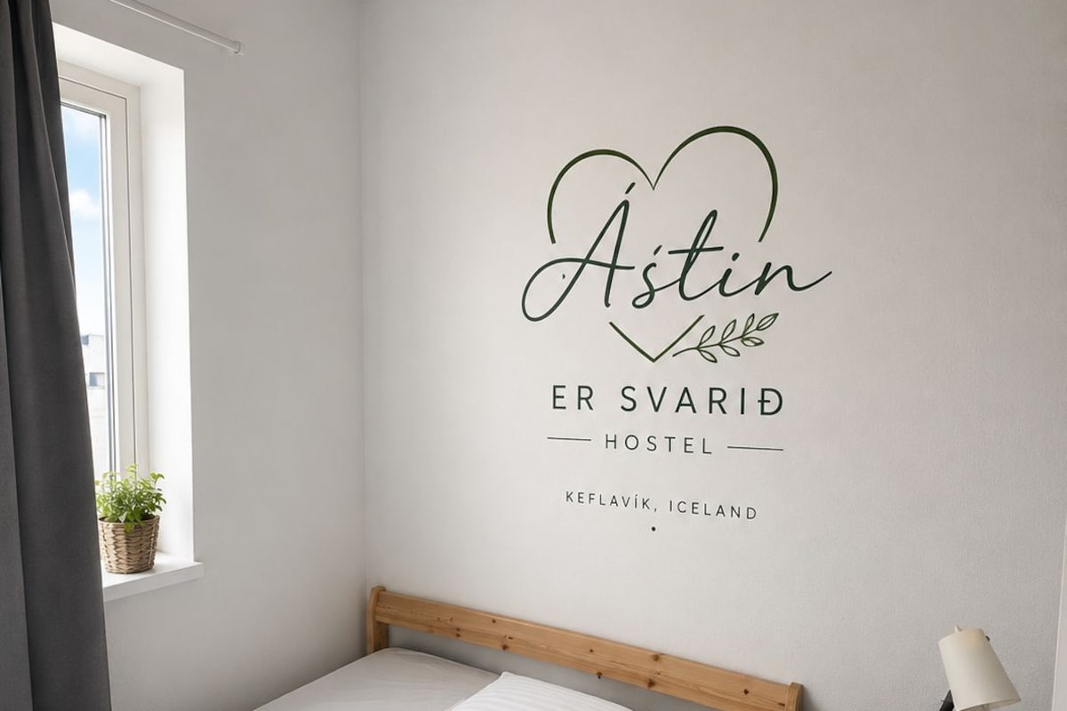A minimalist bedroom with a bed, a bedside table with a lamp, and a wall decoration.