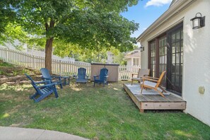 A backyard with a wooden deck, outdoor seating, and a white fence. - MINNeSTAY * Rose Garden Retreat (Minneapolis)