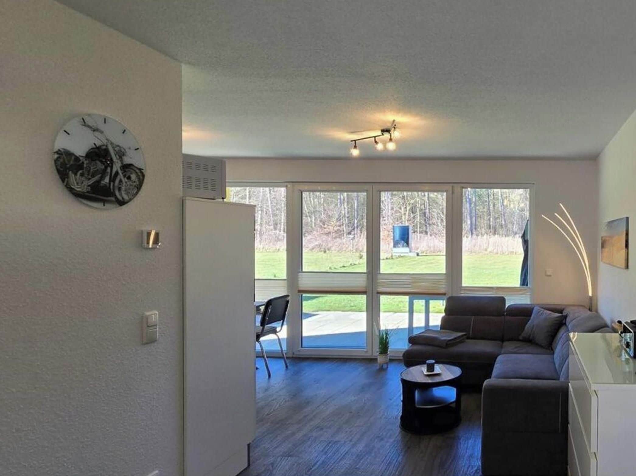 A modern living room with a sofa, a coffee table, and a dining area.