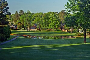 A golf course with a pond, trees, and houses in the background. - Hot Tub, Lake View, Eureka Springs Lakehouse (Eureka Springs)