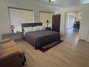 A bedroom with a bed, a nightstand, a lamp, a dresser, and a chair. - Hot Tub, Lake View, Eureka Springs Lakehouse (Eureka Springs)